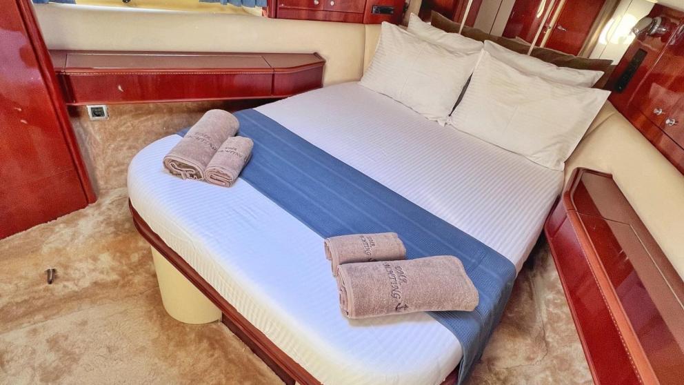 Bedroom with double bed with towels on the yacht